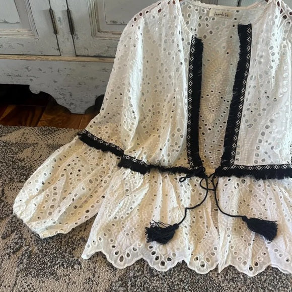White lace dress with black accents on a textured surface