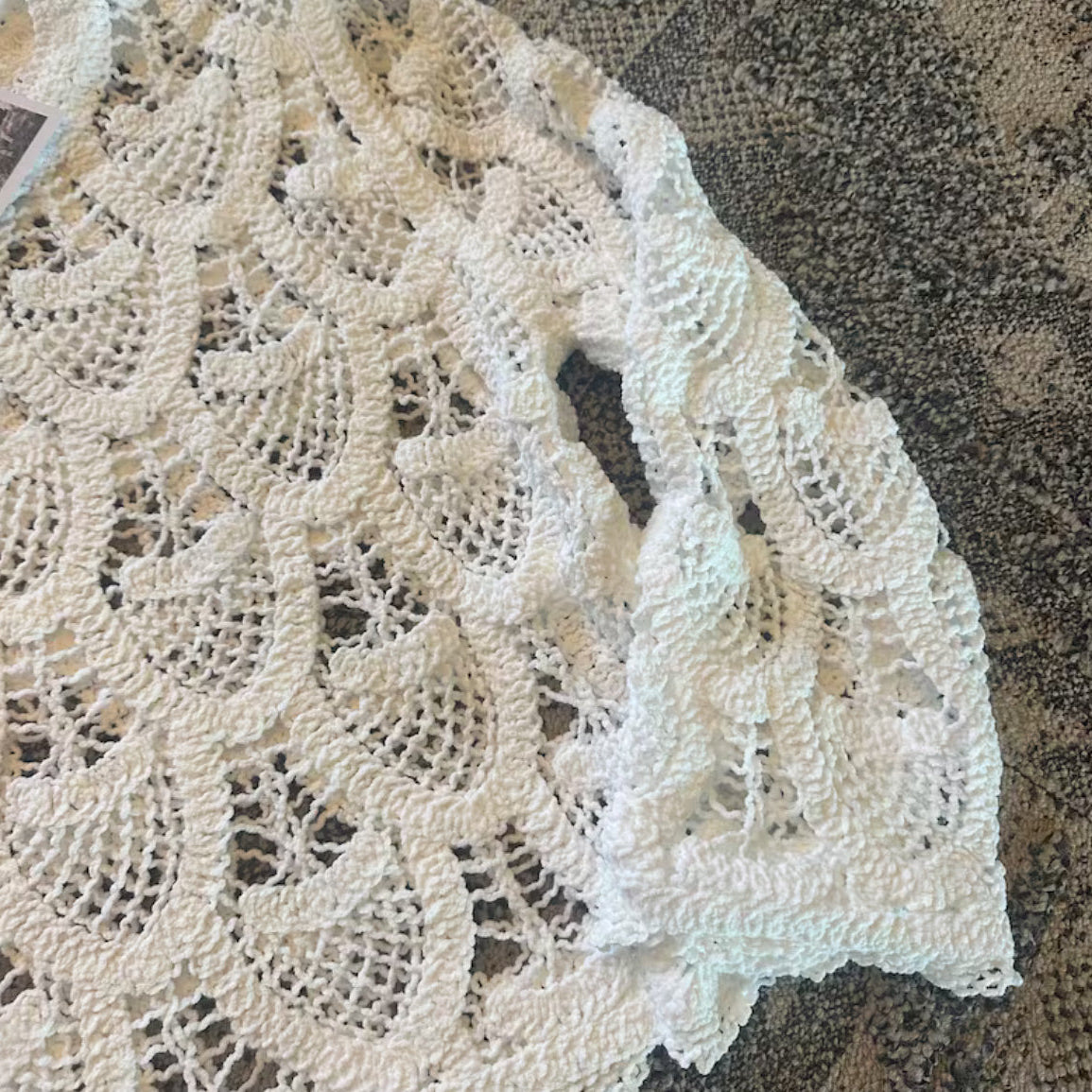 Close-up of a beige lace fabric on a textured brown background