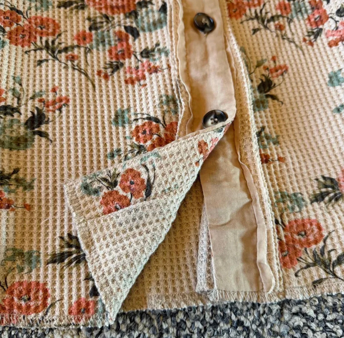 Floral-patterned fabric with a textured texture and buttons.