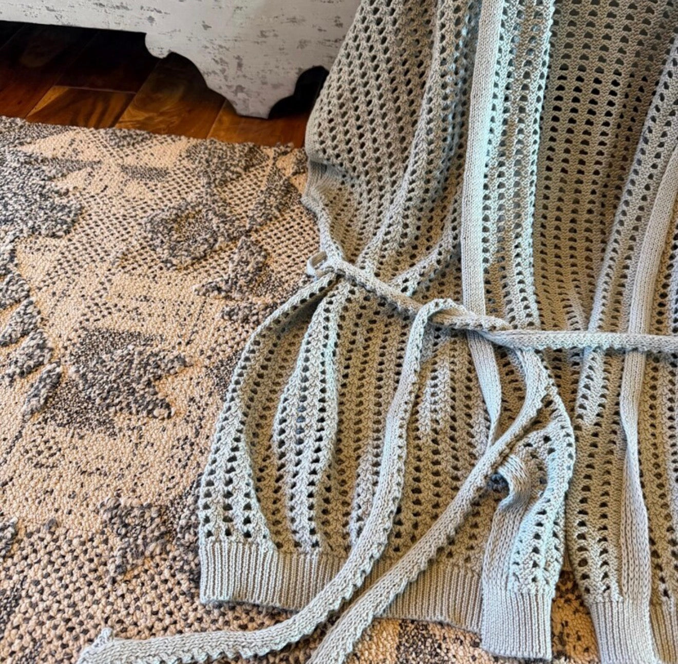 Knitted blanket draped over a textured surface