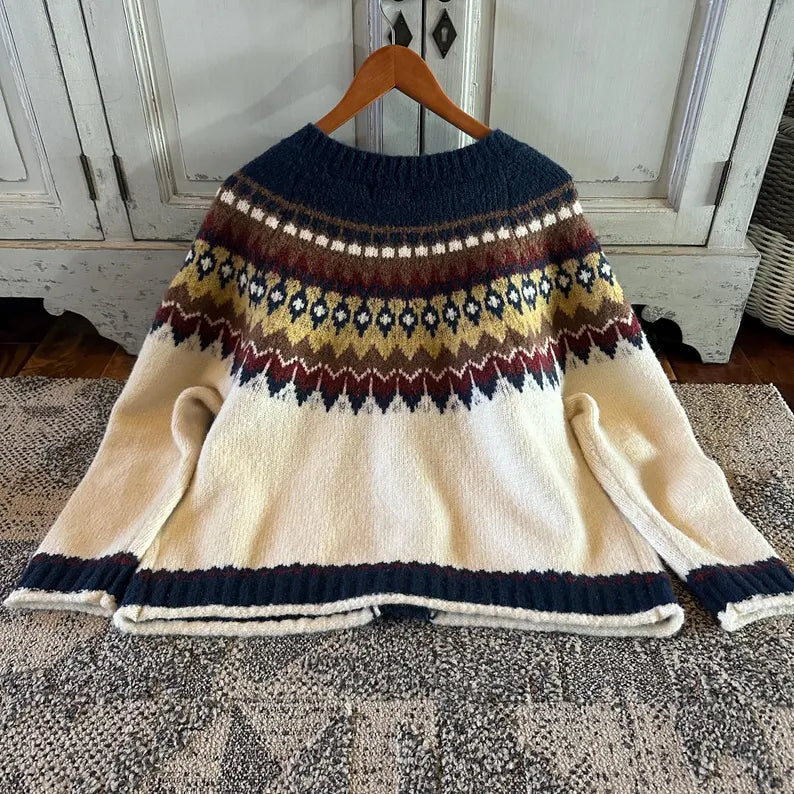 Colorful patterned sweater on a hanger against a wooden door background