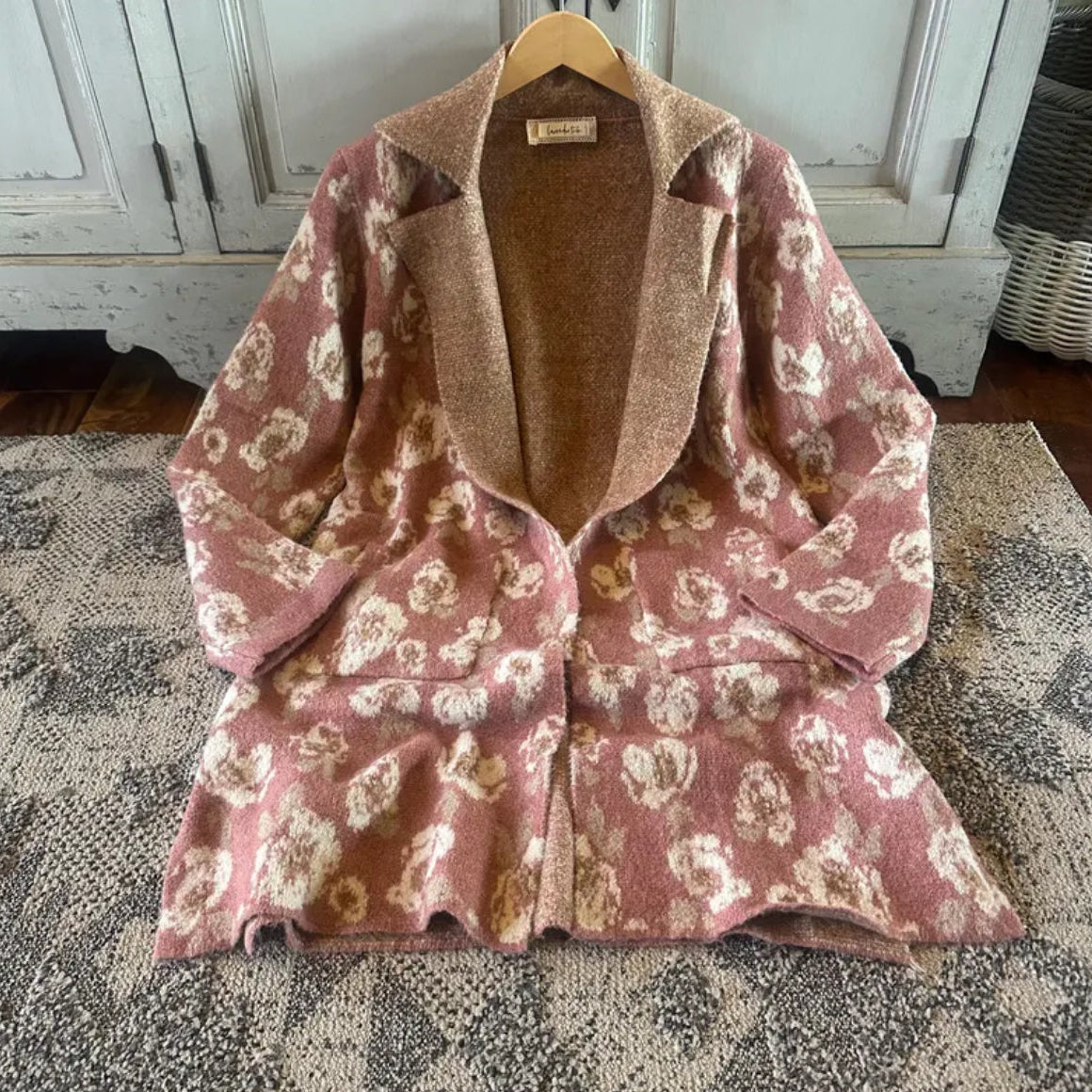 Floral-patterned jacket on a hanger with a wooden background