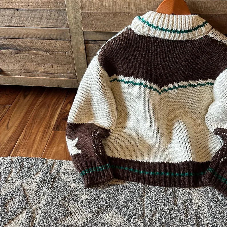 Knitted sweater with brown and white pattern on a wooden surface