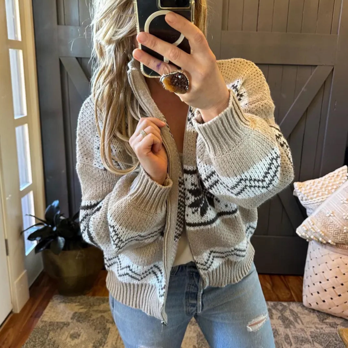 Person wearing a patterned sweater and jeans in a home setting
