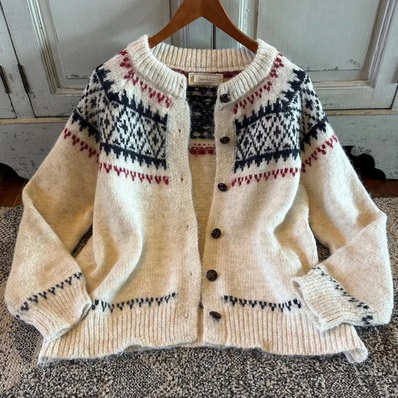 Knitted cardigan with patterned design on a wooden hanger