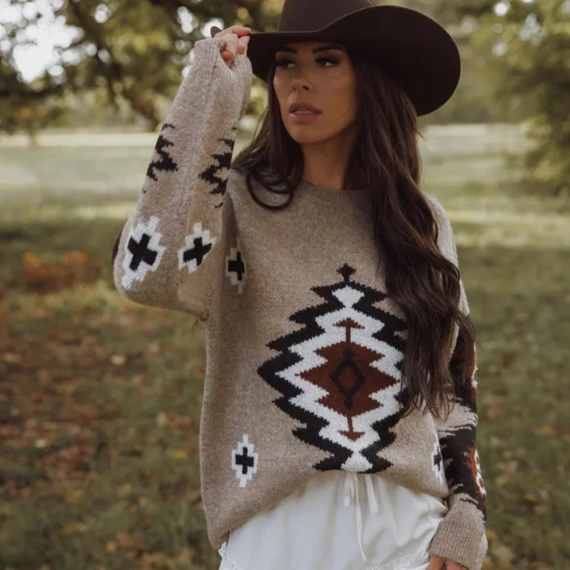 Woman wearing a patterned sweater and hat outdoors