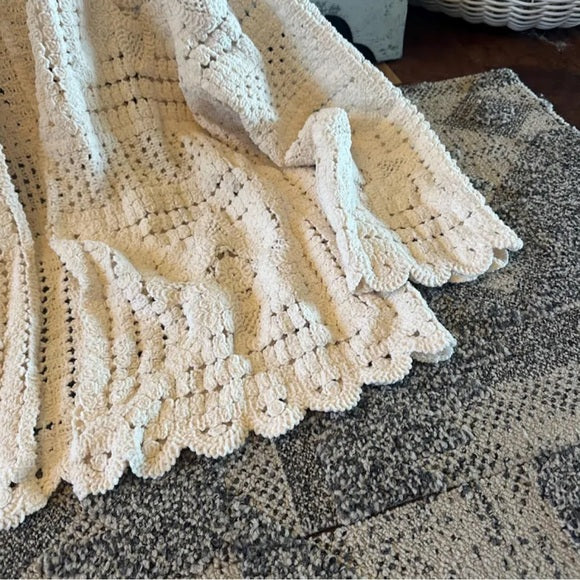 Beige crocheted blanket on a textured surface