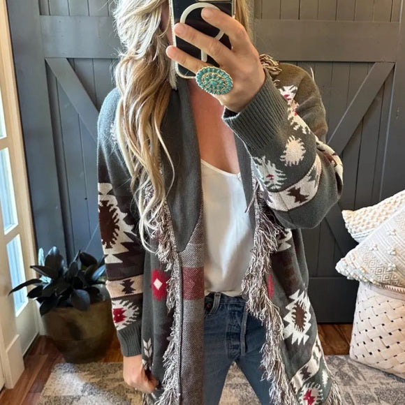 Person wearing a patterned cardigan in a home setting